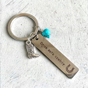 Western cowboy keychain featuring engraved Drive Safe metal tag and silver boot charm
