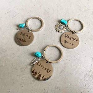Three engraved metal keychains with turquoise beads and feather, sunflower pendants