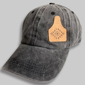 Detail of vintage charcoal grey washed cotton cap with a geometric leather patch