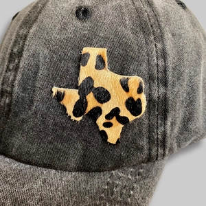 Detail of grey washed canvas baseball cap featuring a cow print Texas map patch design