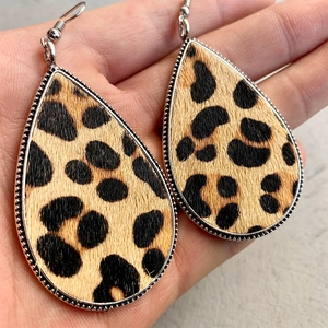 Macro shot of leopard print teardrop earring with metallic beaded edge and textured faux fur