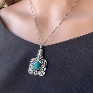 Collier bohème turquoise avec pendentif étiquette de bétail et reliefs floraux vintage