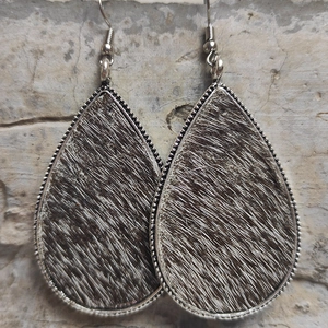 Detail of silver teardrop earrings with brown leopard print faux fur texture