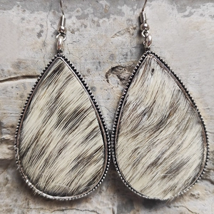 Detail of teardrop earrings with silver beaded edges and black and white faux fur texture