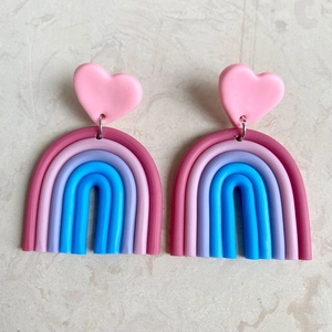 Detail van handgemaakte regenboog hart oorbellen van zachte klei met felle kleuren