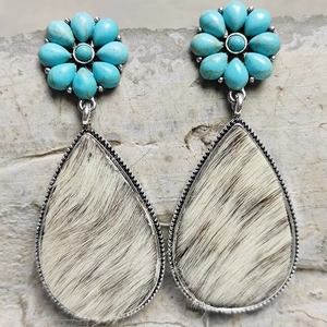 Detailed view of bohemian teardrop earrings featuring cowhide inlay and turquoise flowers