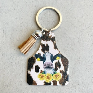 Detail of western cow print leather tag keychain with sunflower and brown suede tassel