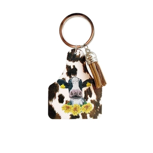 Western cowboy style cow tag keychain with brown white spots and fringe tassel