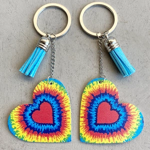 Détail macro de porte-clés en cuir en forme de cœur tie-dye avec glands bleus élégants