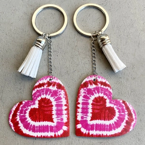Porte-clés cœur en cuir dégradé avec pompon blanc et anneau argenté sur fond gris
