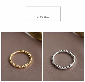 Primer plano de pendientes de aro trenzados de plata s925 en oro y plata