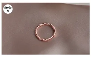 Primer plano de Style A mini aro de oro rosa con textura trenzada sobre seda marrón