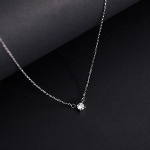 Dettaglio di una collana in argento con ciondolo in zircone rotondo incastonato a quattro griffe
