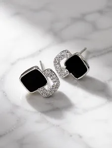 Detalle de pendientes de botón de esmalte negro con acabado de plata pulida espejo