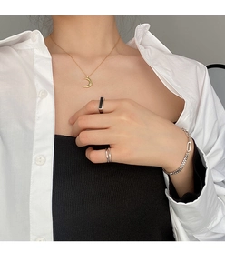 Modelo con conjunto minimalista de anillo plateado y collar con colgante de luna dorada