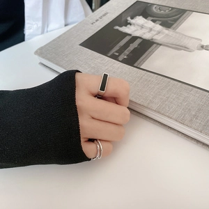 Set de anillos plateados con detalle negro rectangular y diseño ondulado minimalista