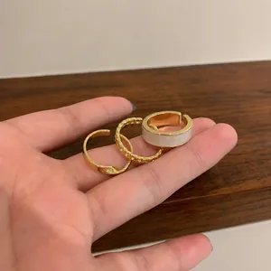 Three-piece gold adjustable ring set featuring twist, chain, and white inlay designs