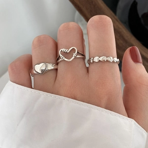 Three-piece silver heart ring set featuring solid heart seal and hollow woven designs