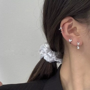 Detailansicht der silbernen Schmetterlings-Ohrringe und Zirkonia-Stecker am Ohr