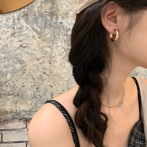 Eleganti orecchini a cerchio dorati lucidi per donna indossati da una modella di moda