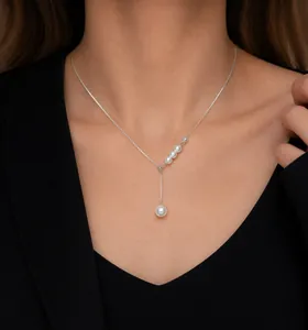 Détail du collier de perles argentées avec pendentifs en cascade sur un mannequin