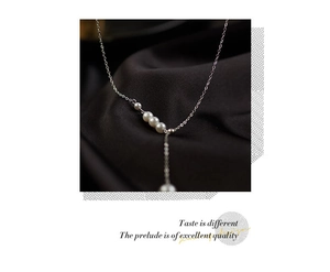 Vue détaillée d'un collier plaqué argent avec quatre perles blanches sur tissu de soie