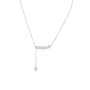 Collier en perles dorées avec pendentif à franges à plusieurs niveaux sur fond blanc