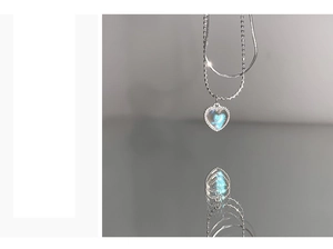 Detail of silver double-layered heart pendant necklace with blue moonstone and snake chain