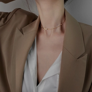 Collana choker in argento placcato oro minimalista con piccoli ciondoli sul modello