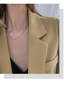 Nahaufnahme einer zweilagigen versilberten Halskette am Modell für schicken Lagenlook
