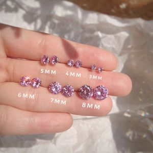 Comparación de tamaños de pendientes de circón rosa de 3mm a 8mm en los dedos