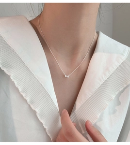 Détail d'un collier pendentif nœud en argent avec zircons brillants sur une chaîne fine