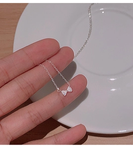 Détail du pendentif nœud en argent avec zircons scintillants sur une chaîne délicate