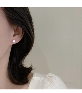 Primer plano de pendientes de circonita rosa en modelo para un estilo de joya minimalista