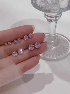 Detalle de cinco tamaños diferentes de pendientes de circonita rosa en una mano