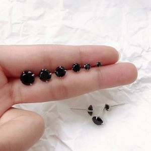 Comparaison détaillée de clous d'oreilles en zircon noir en six tailles sur une main