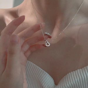 Primer plano del colgante de corazones entrelazados con cristales en cadena de plata
