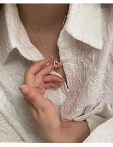 Nahaufnahme einer goldenen Halskette mit ineinandergreifenden Ringen auf Modelhals