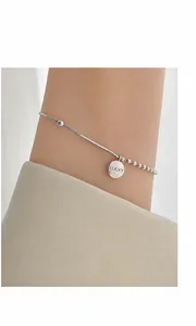Details von Schlangenkette und Perlenarmband aus Silber mit Lucky-Anhänger
