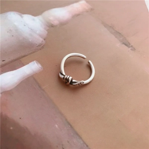 Primer plano de anillo de nudo plateado vintage con acabado antiguo y diseño abierto