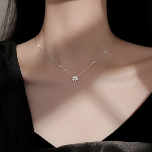 Collar de trébol de cuatro hojas en plata con circonitas usado por una modelo