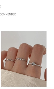 Three-piece silver ring set featuring minimalist bands, bow and flower designs on finger