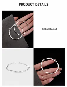 Vista detallada de la pulsera Mobius plateada con diseño minimalista trenzado y puño abierto