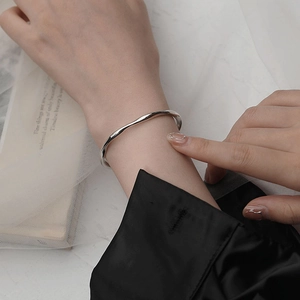 Pulsera Mobius ondulada bañada en plata para mujer con diseño fluido y minimalista