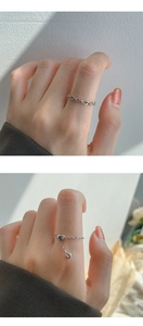 Detailed view of silver heart pendant ring and chain band worn on fingers