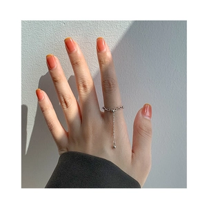 Detail showing an adjustable silver heart chain ring with a hanging bead on a finger