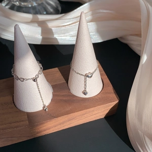 Silver plated heart chain adjustable rings displayed on a premium wooden display stand