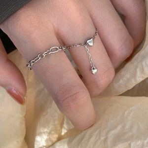 Silver heart chain adjustable ring with charm pendant on female model hand