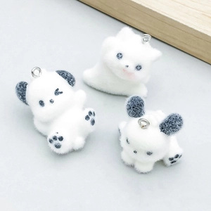 Détail macro de trois breloques blanches floquées en forme de chiot et chat pour bijoux