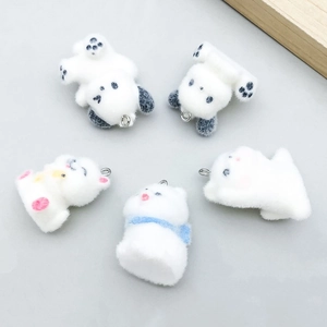 Détail de cinq breloques animaux floquées blanches avec anneaux pour bijoux DIY